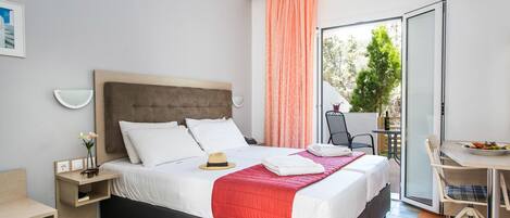 Una habitación de hotel moderna con una cama, un escritorio, una silla y un balcón con mesa y sillas.