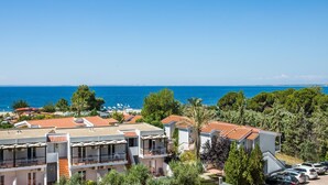 Un hotel frente al mar con varios balcones, zona de piscina y vistas al océano.