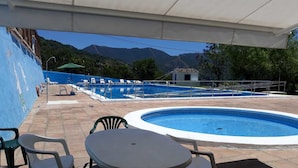Zona de piscina con una piscina pequeña, una mesa y sillas.