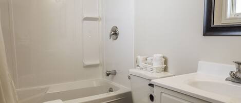 Une salle de bain avec une baignoire, des toilettes et un meuble-lavabo.