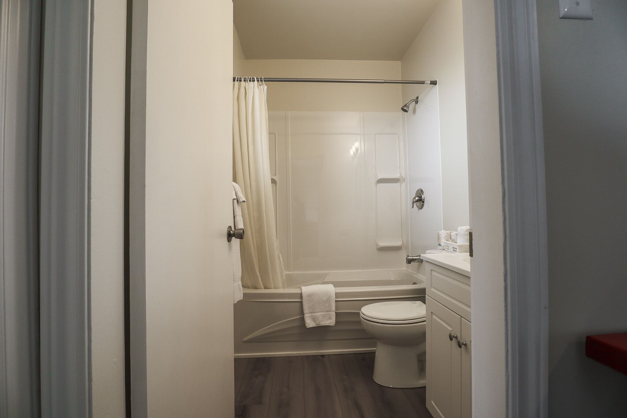 A small, compact bathroom with a shower, toilet, and sink.