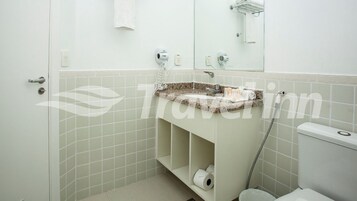 Un baño con lavamanos, inodoro y perchero para toallas.