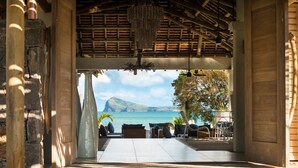 An open-air lounge with a view of the sea and a mountainous landscape. - Zilwa Attitude (Calodyne)