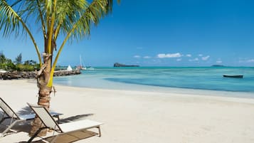 On the beach, white sand, sun loungers, beach umbrellas