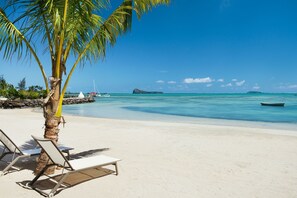 On the beach, white sand, sun-loungers, beach umbrellas