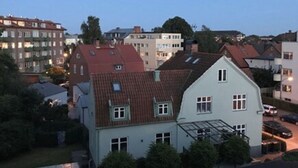A multi-story residential building with a sloped roof, multiple windows, and a visible garage entrance. - MillasVilla (Lund)