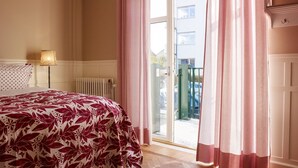 A bedroom with a bed, a radiator, and a view of the outside. - MillasVilla (Lund)