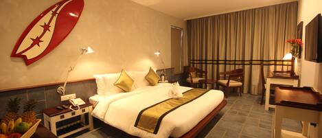 A hotel room with a bed, bedside table, lamp, and a large wall decoration.