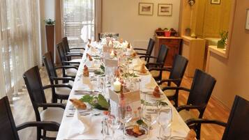 A long dining table set with chairs, candles, and tableware.