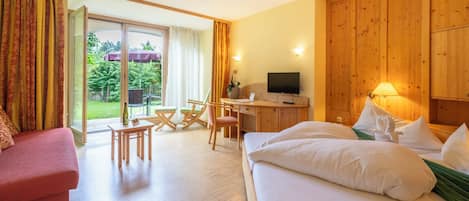 Una habitación de hotel con cama, sofá, escritorio y televisor.