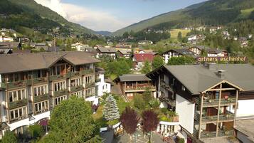 Un bâtiment de style alpin traditionnel, doté de nombreux balcons, d’une cour intérieure et offrant une vue sur un village de montagne.