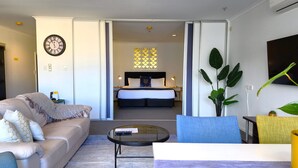 A modern hotel room with a sofa, a coffee table, and a bed with a headboard. - U Residence Hotel, Signature Collection by BW (Wellington)