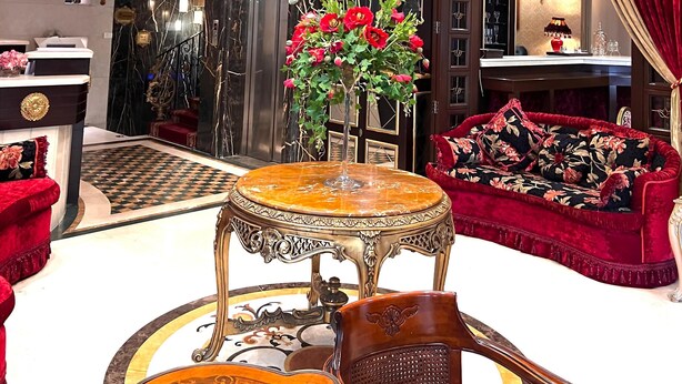 A luxurious interior with a grand chandelier, ornate ceiling, and a red velvet sofa. - Q Hotel (Beirut)