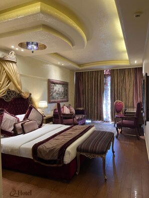 Habitación de hotel con una cama grande, un escritorio, una silla y un cuadro en la pared.
