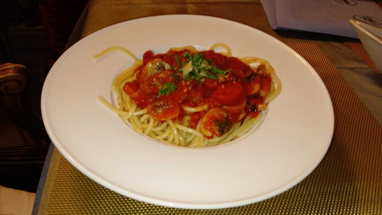 Une assiette de spaghettis à la sauce tomate et aux herbes.