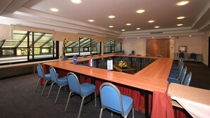 A conference room with a long table, blue chairs, and large windows. - Flores (Porec)