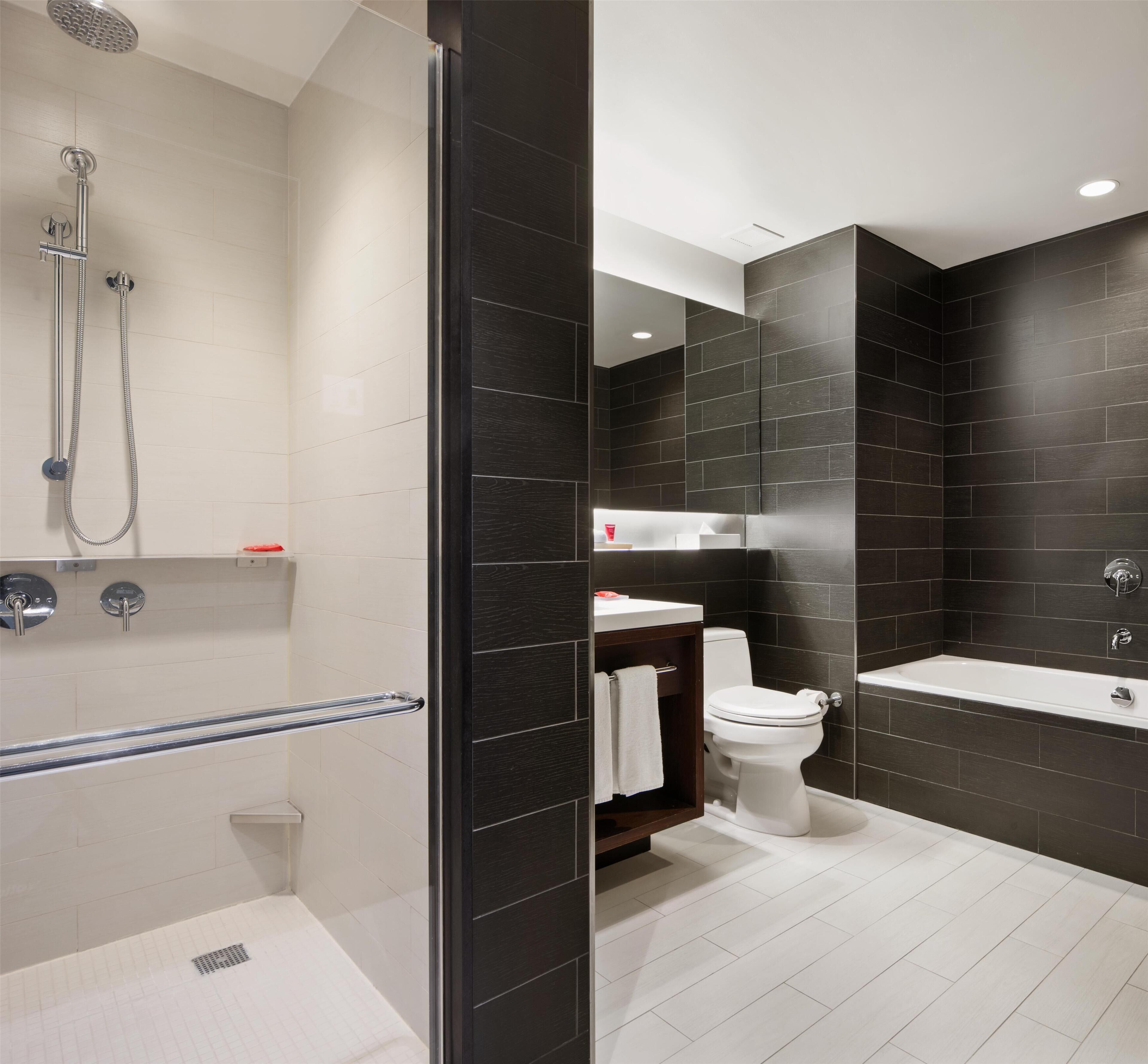 A modern bathroom with a shower, toilet, and bathtub.
