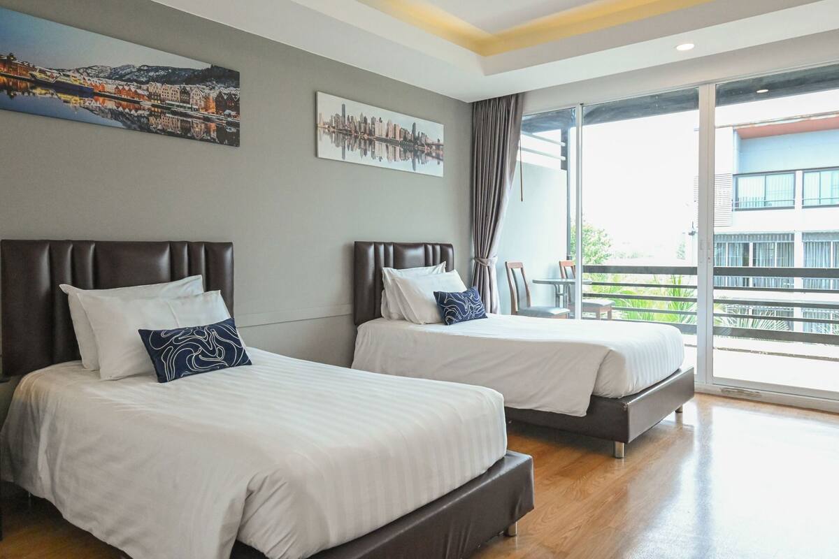 Ein Hotelzimmer mit zwei Betten, einem Balkon mit Aussicht und Bildern an den Wänden.
