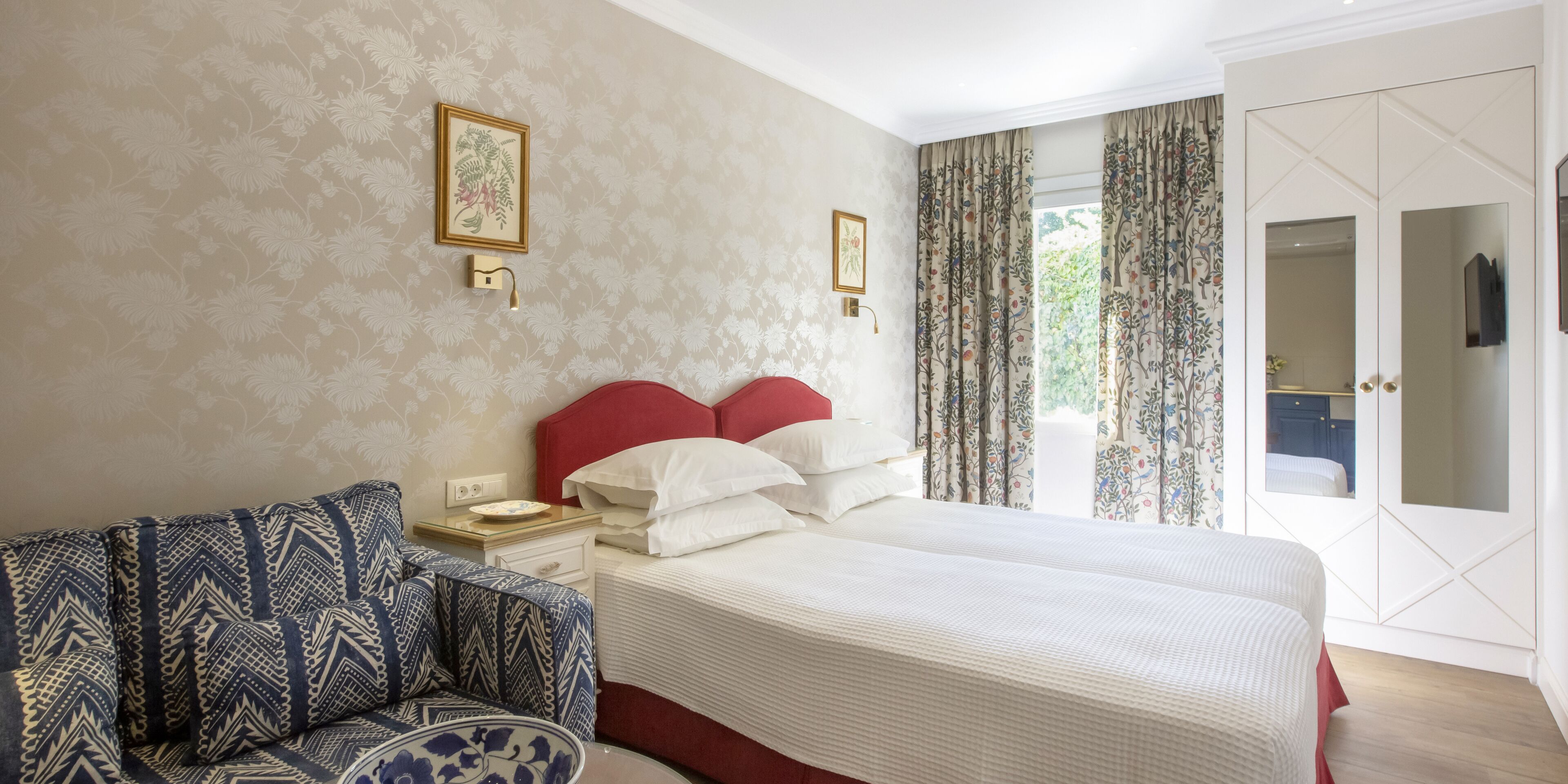 Une chambre d’hôtel comprenant un lit, un canapé, une table de chevet et une armoire.