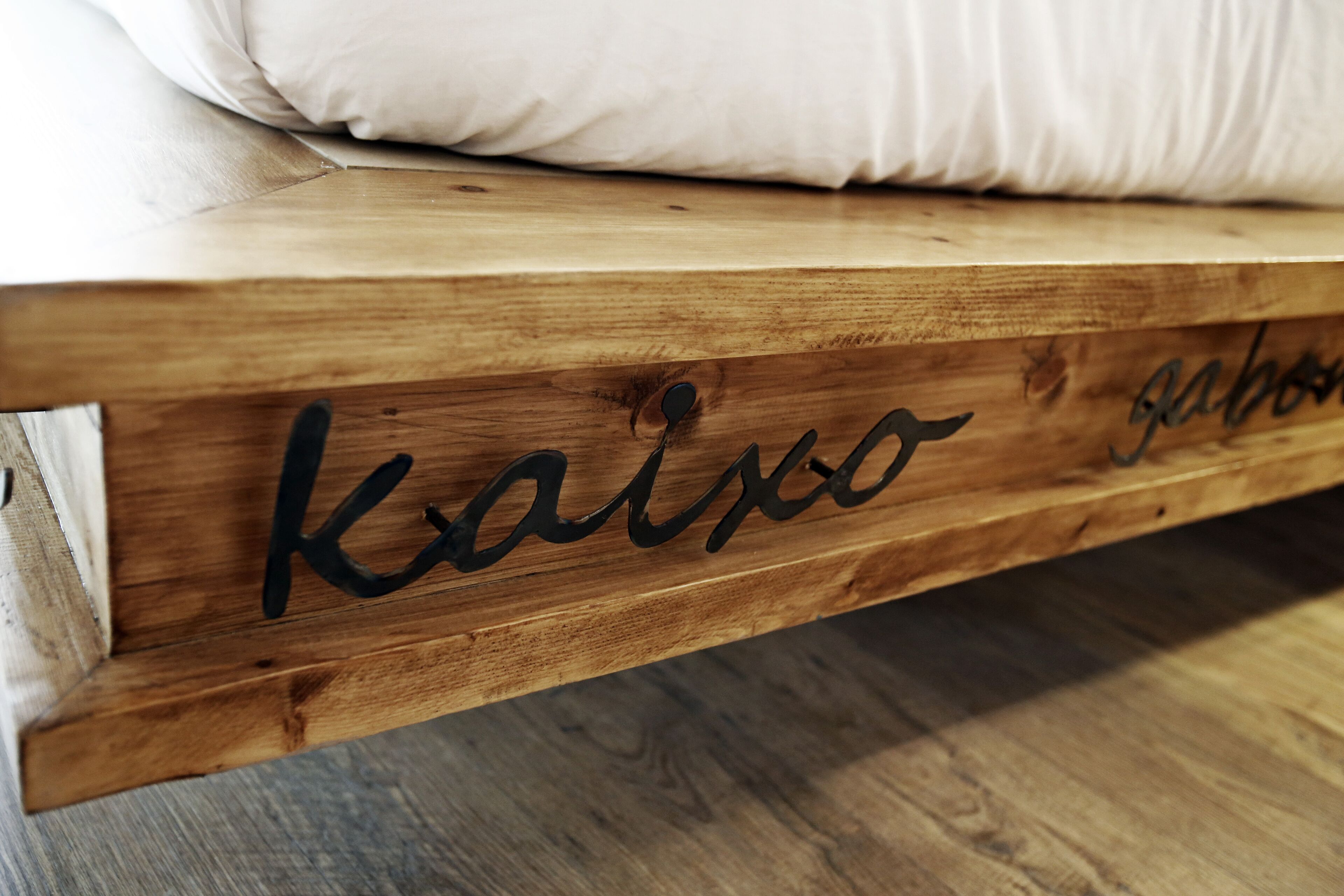 Estructura de cama de madera con la palabra "kaiso" escrita en ella.