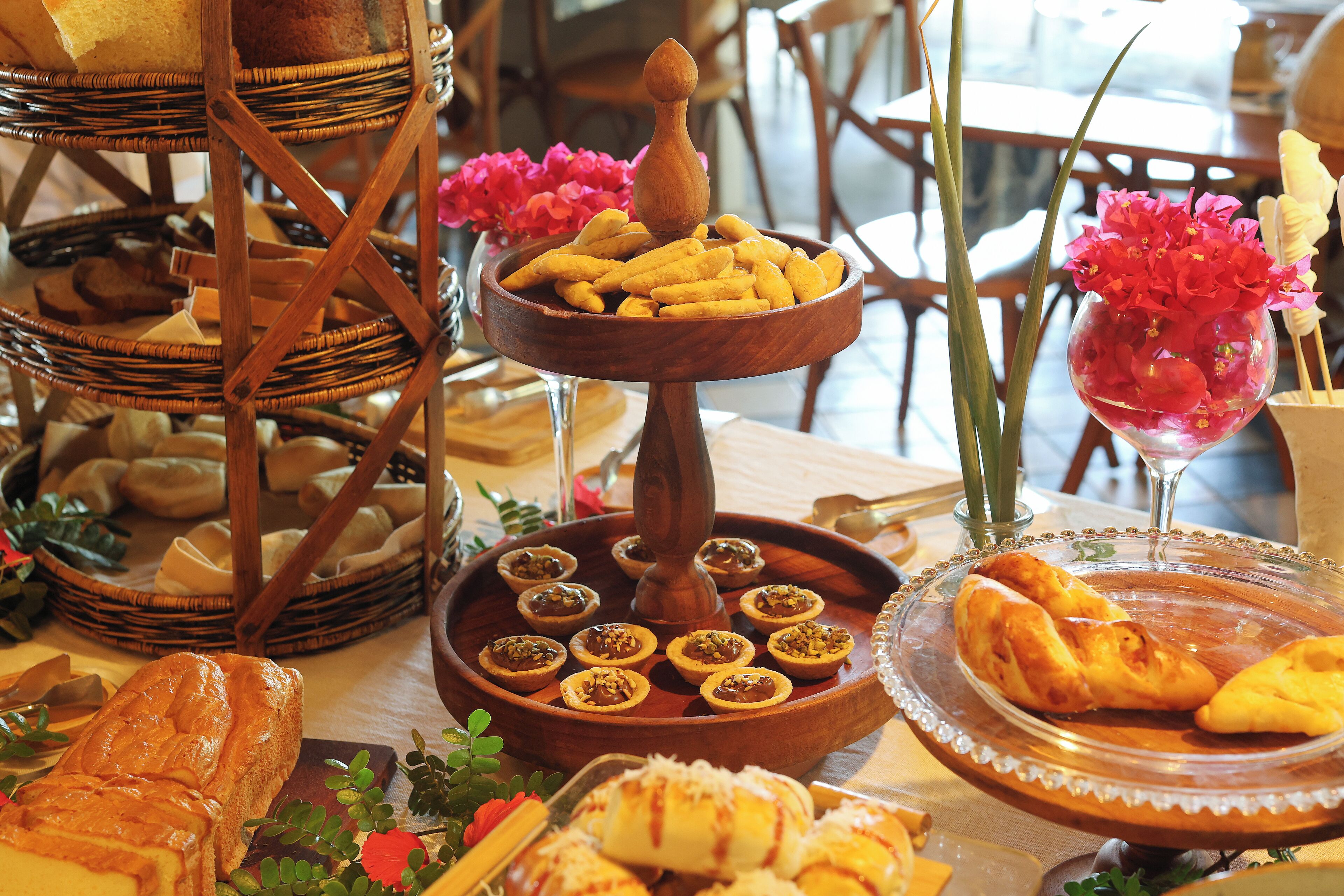 A table with various food items including bread, pastries, and a bowl of fruit.