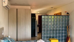 Une chambre à coucher comprenant un lit, une armoire, une petite table et un objet décoratif.
