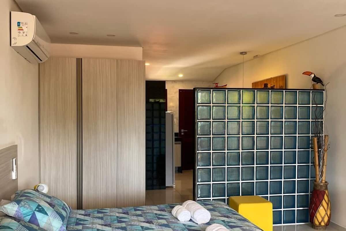 Un dormitorio con una cama, un armario, una mesita y un adorno.