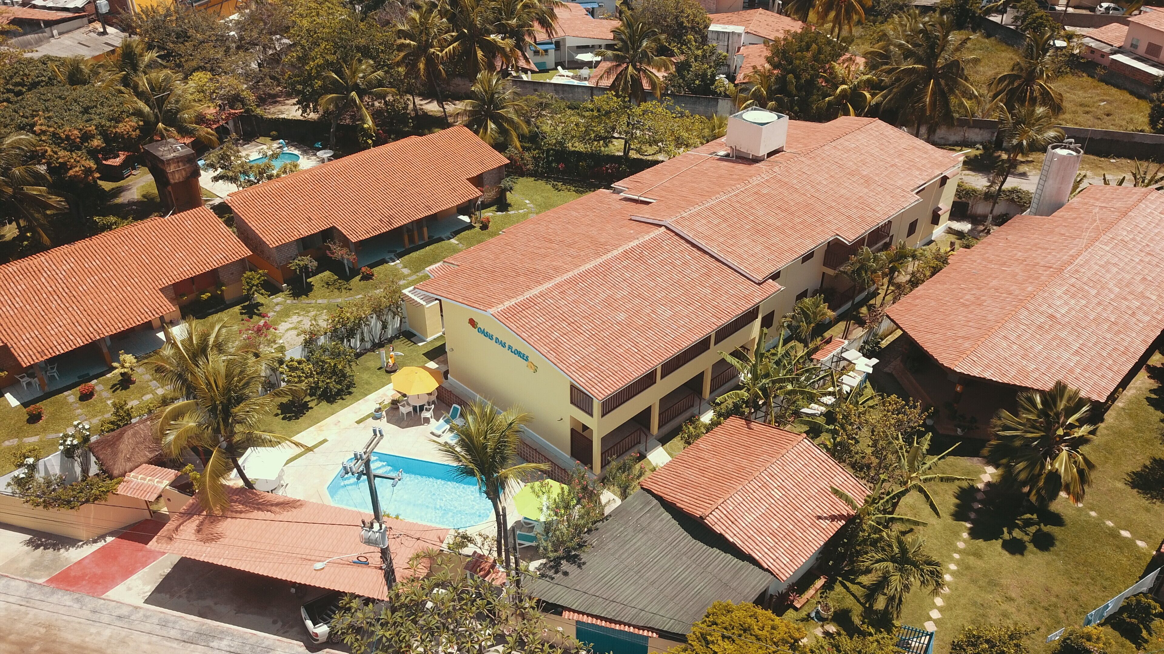 Un quartier résidentiel comprenant plusieurs maisons, une piscine et un grand bâtiment portant une enseigne.
