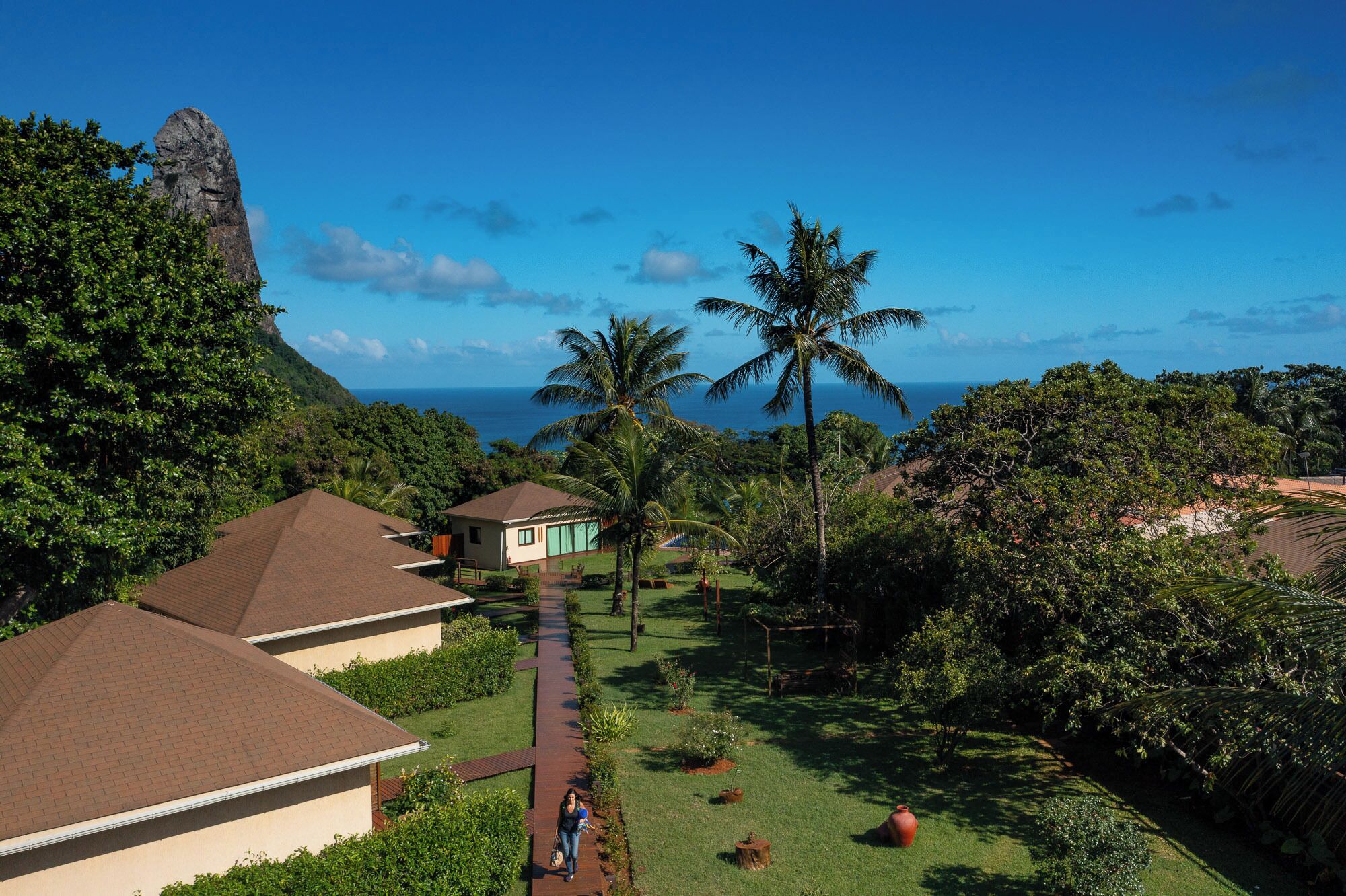 A resort with multiple bungalow-style buildings, a central pathway, and lush greenery.