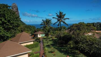 Um resort com várias construções tipo bangalô, um caminho central e vegetação exuberante.