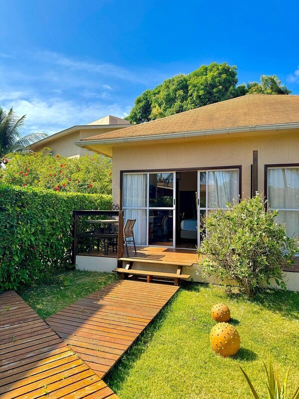 Una casa moderna con patio, puerta corrediza de vidrio y jardín bien cuidado.
