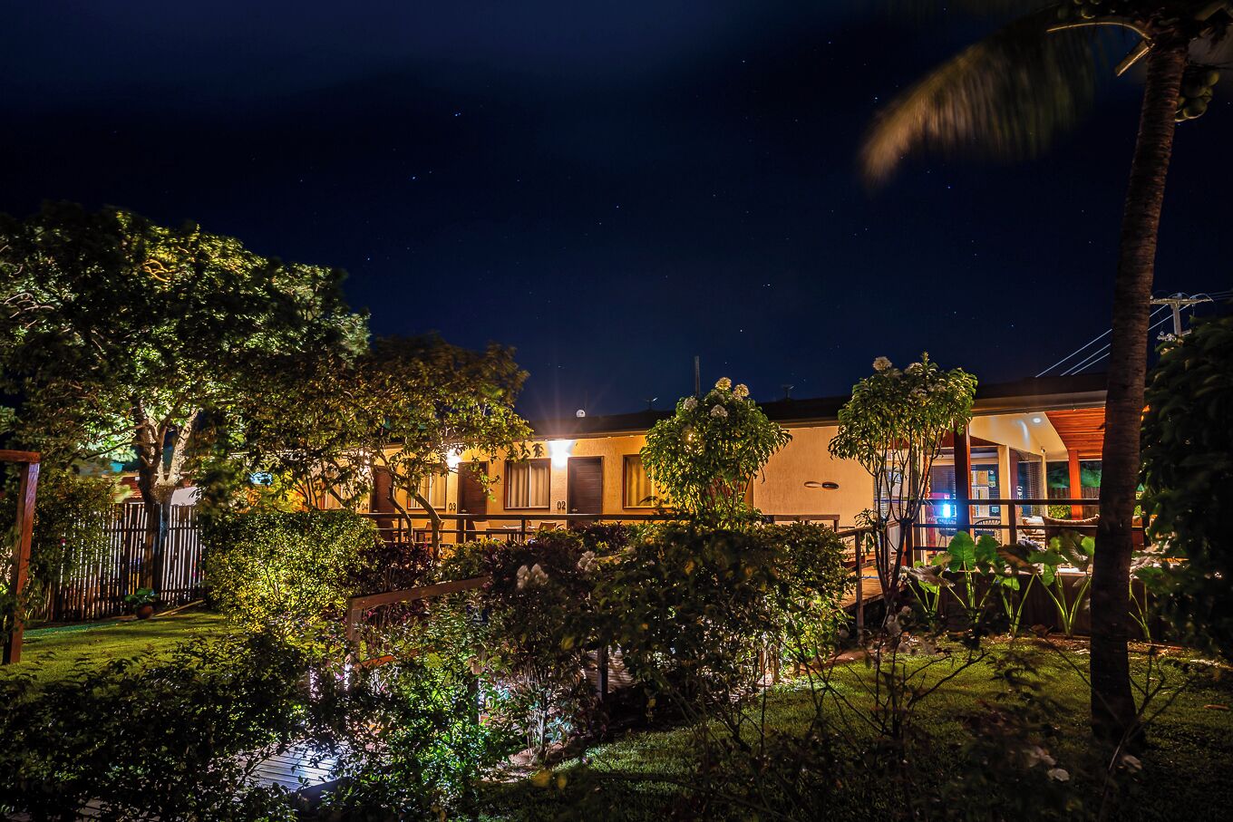 A well-lit hotel with multiple rooms, a garden area, and a pool.