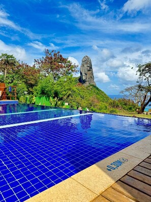 Una piscina al aire libre, sillones reclinables de piscina