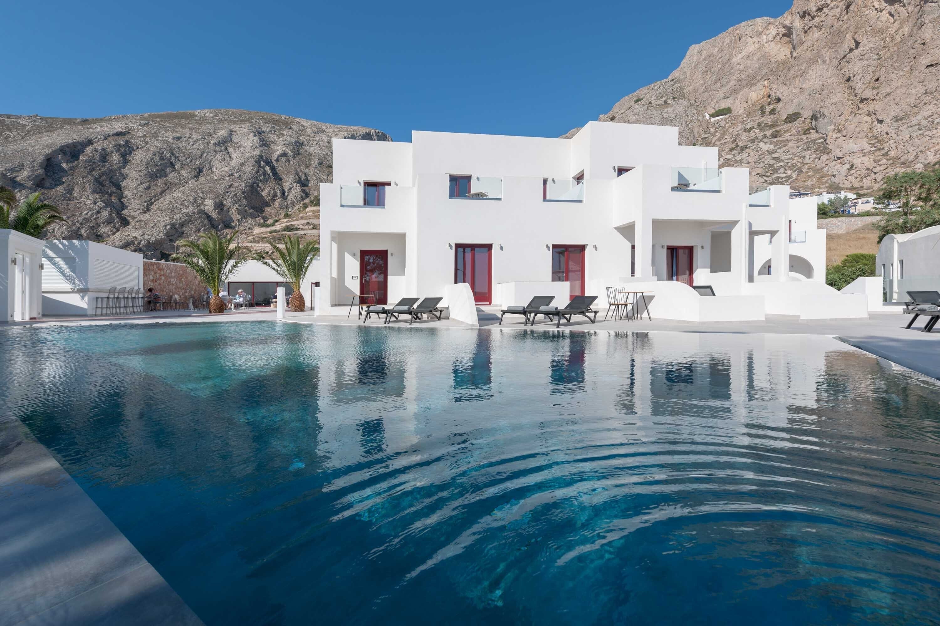 Una piscina al aire libre, sombrillas, tumbonas