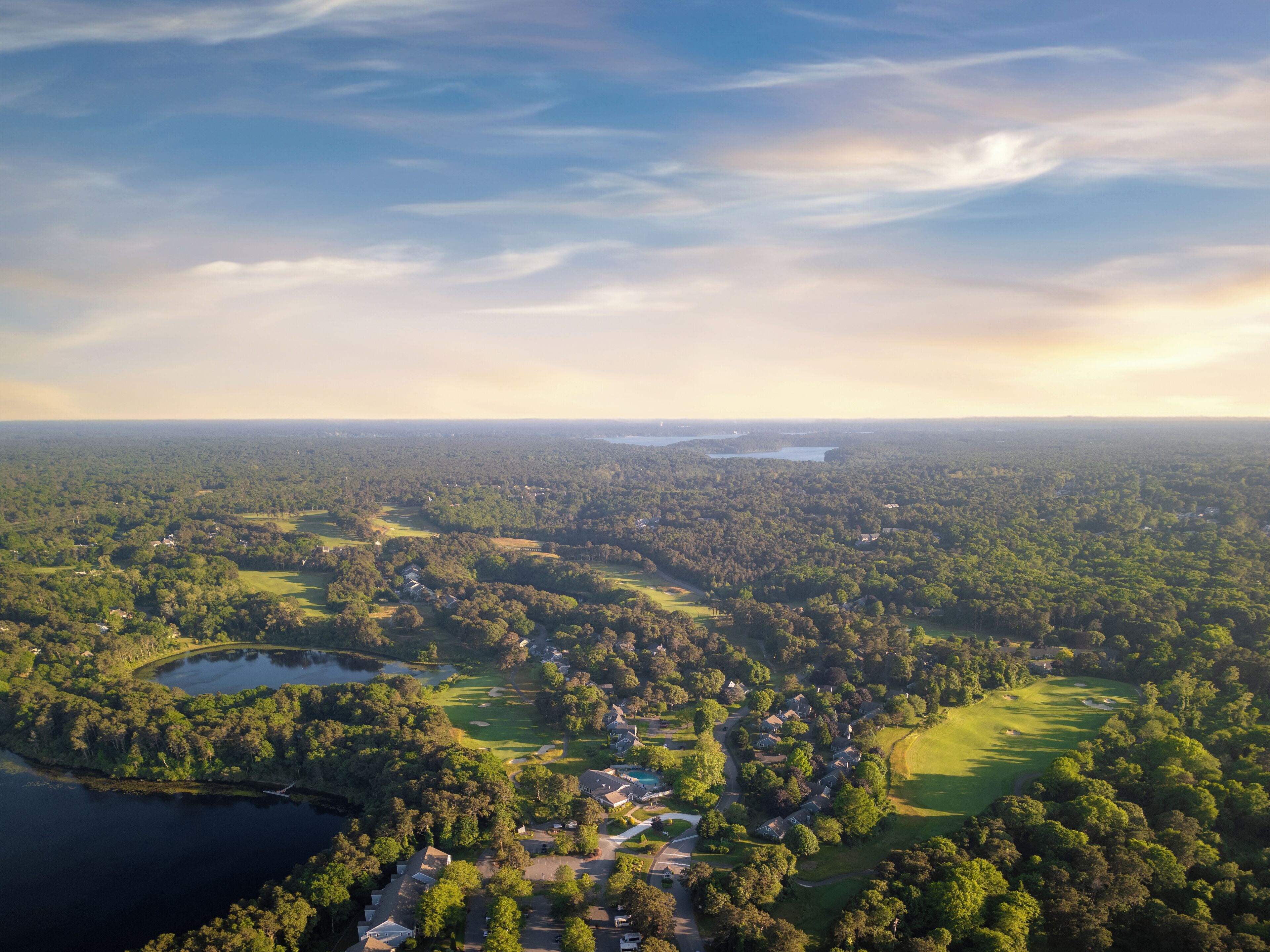 Vista aérea de una zona residencial con casas, carreteras y un campo de golf.