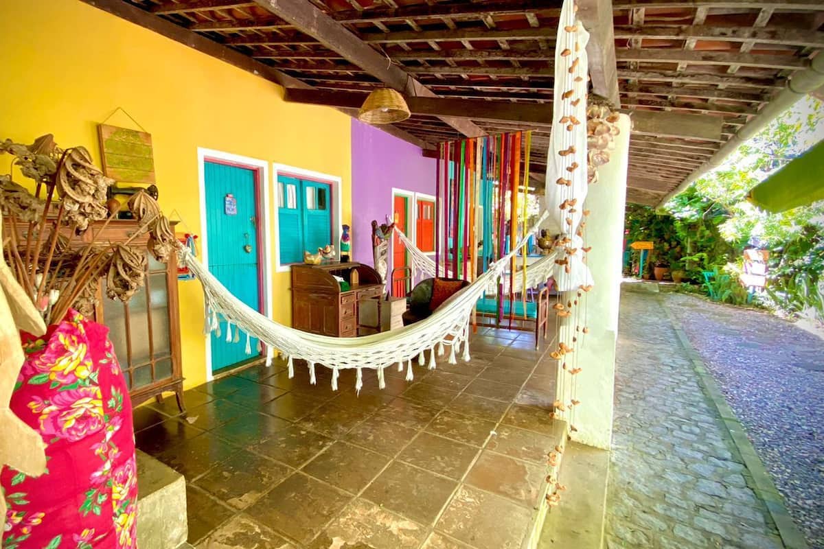 Um interior colorido com uma rede, móveis de madeira e piso de azulejos.