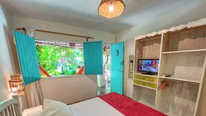 Een slaapkamer met een bed, een televisie en een kledingkast.
