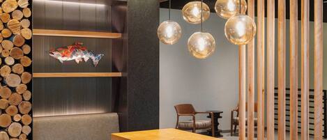 A modern interior with a wooden dining table, unique stools, and a decorative wall with logs.