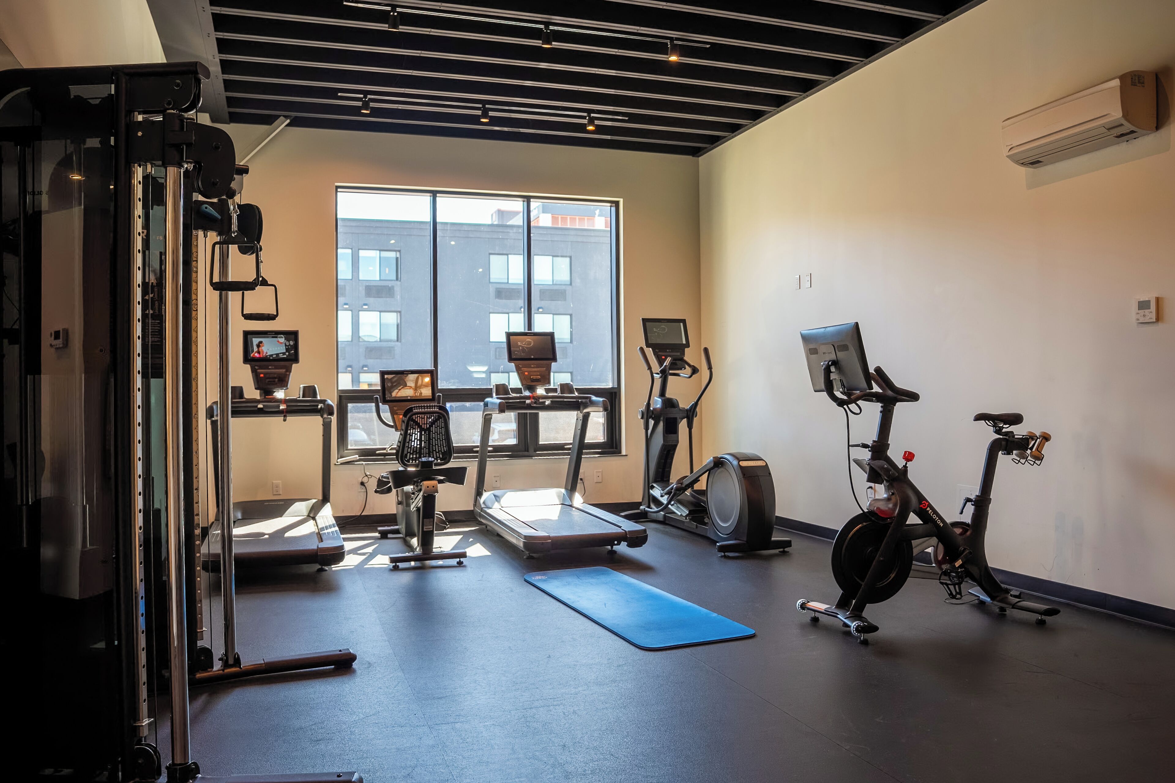 A gym with exercise equipment, a treadmill, an elliptical, and a stationary bike.