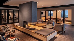 Una sala de estar moderna con chimenea, asientos cómodos y ventanas grandes.