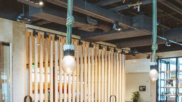 Un interior de restaurante con asientos tipo cabina, lámparas colgantes y un tabique de madera.
