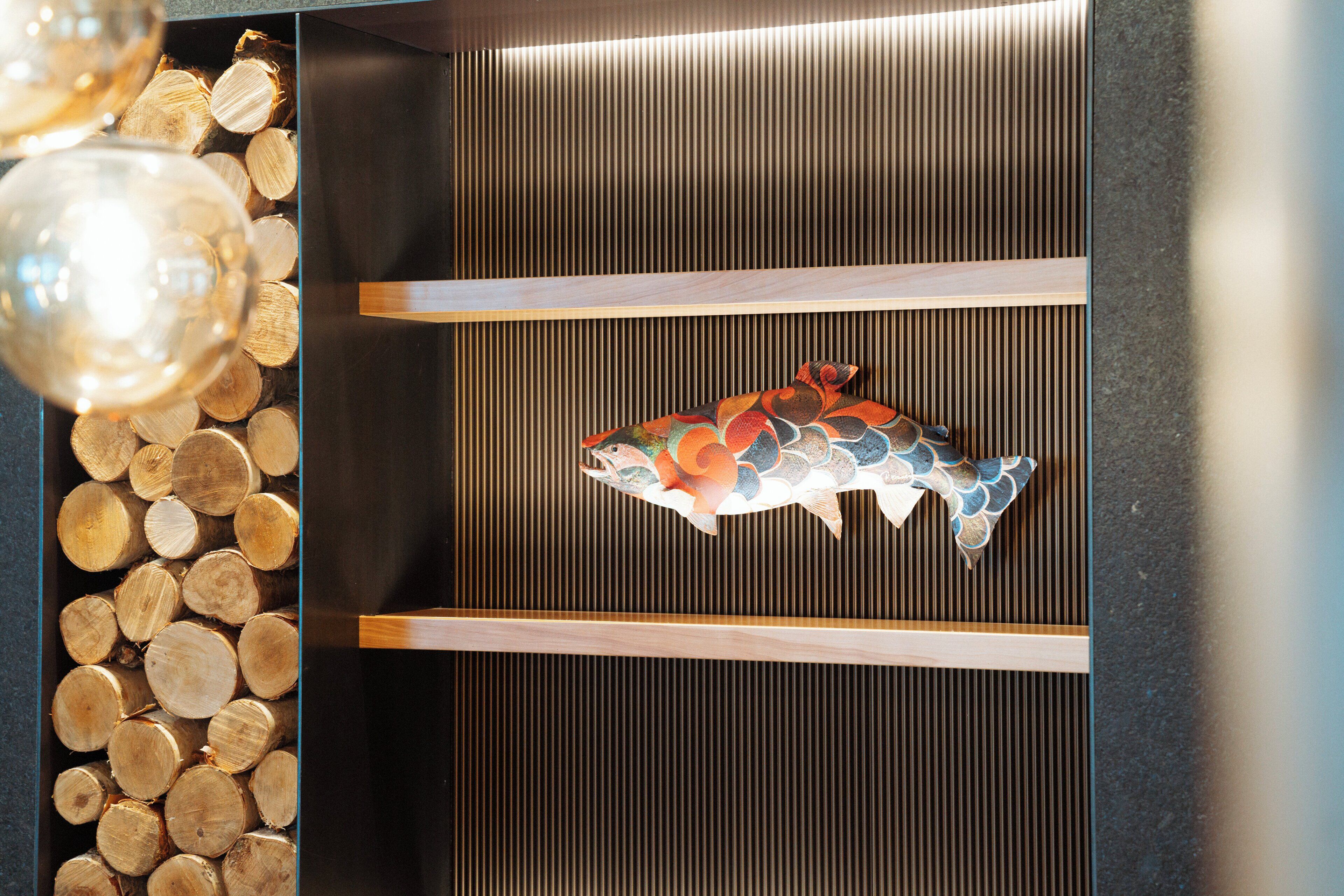 A wooden shelf with a decorative fish sculpture.