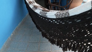 A hammock in a room with blue walls and tiled flooring. - Morada Azul (Ipojuca)