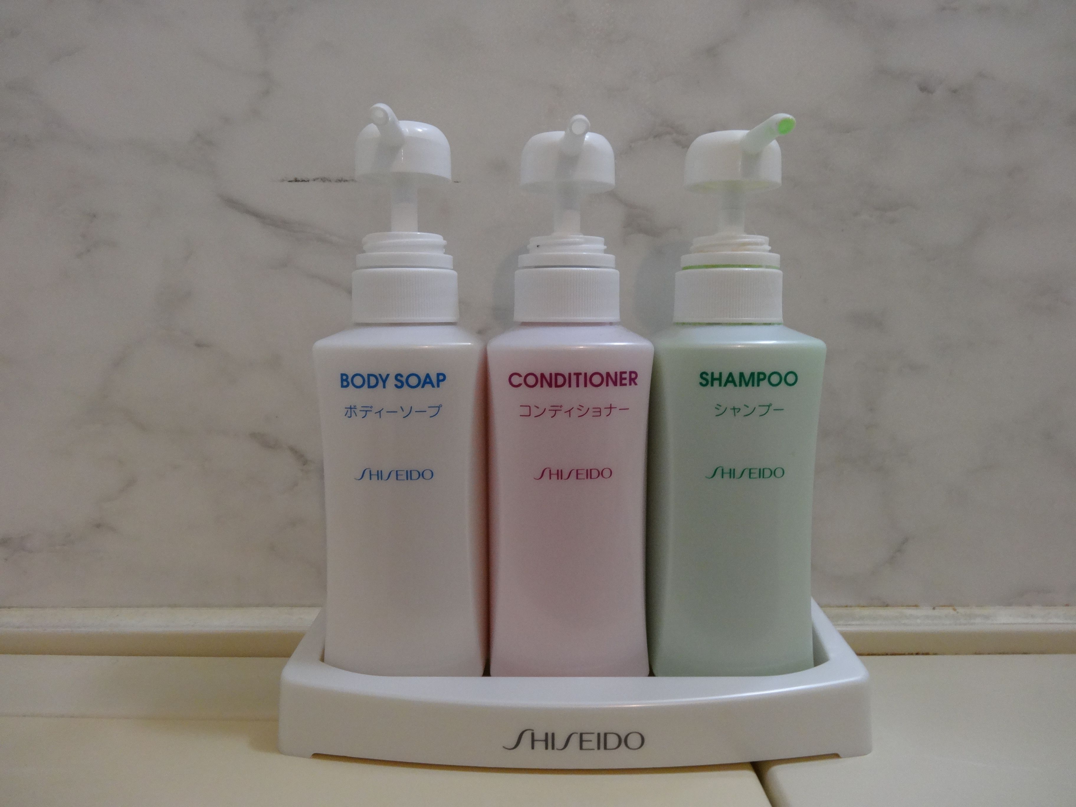 Three bottles of SHISEIDO personal care products on a white tray.