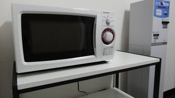 Un four à micro-ondes blanc, avec un panneau de commande, posé sur une table blanche.