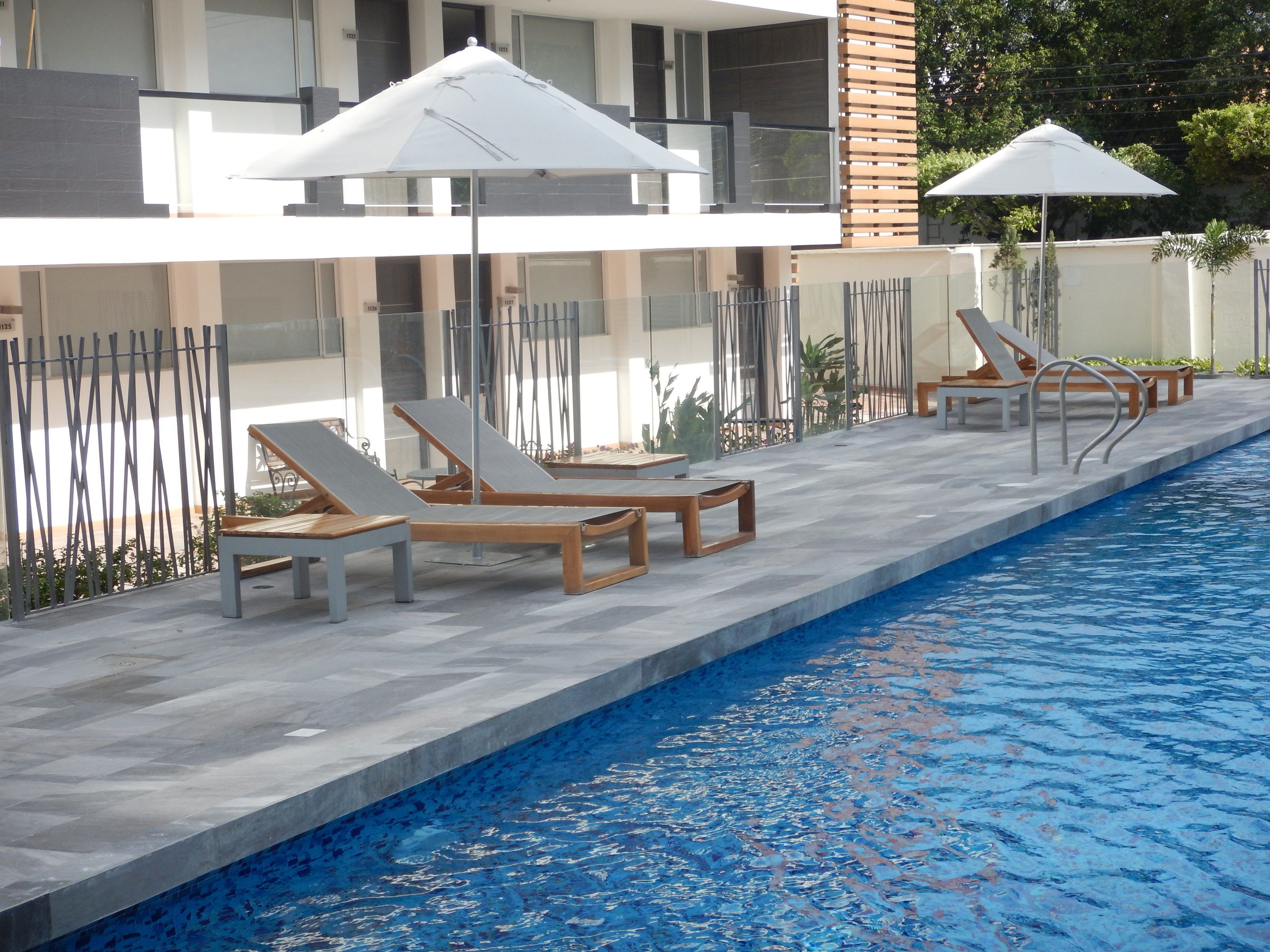 Una piscina al aire libre, sillones reclinables de piscina