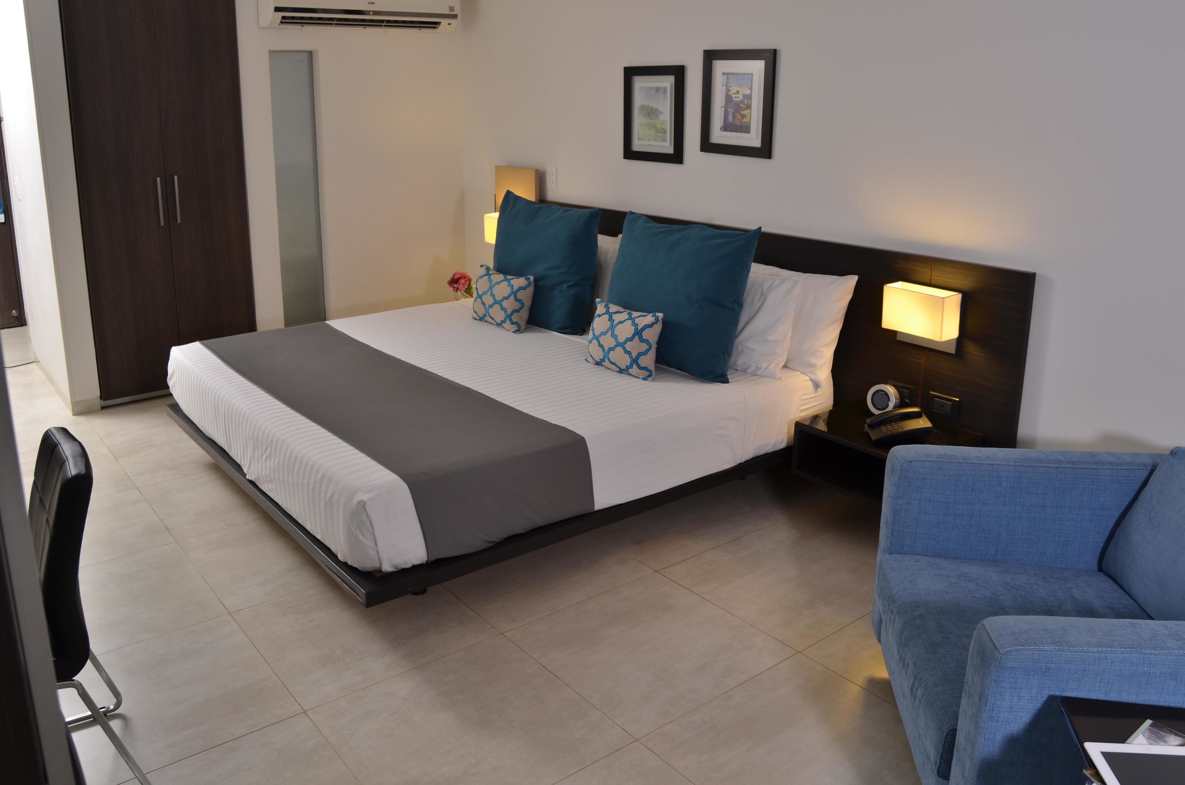 A neatly arranged hotel room with a bed, bedside lamps, a desk, and a chair.
