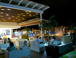 Un espacio al aire libre con mobiliario moderno y una fuente de agua.