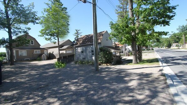 A residential street with houses, trees, and a clear sky.