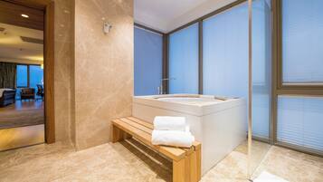 Relax in a spacious bathroom with a bathtub and a comfortable bench.
